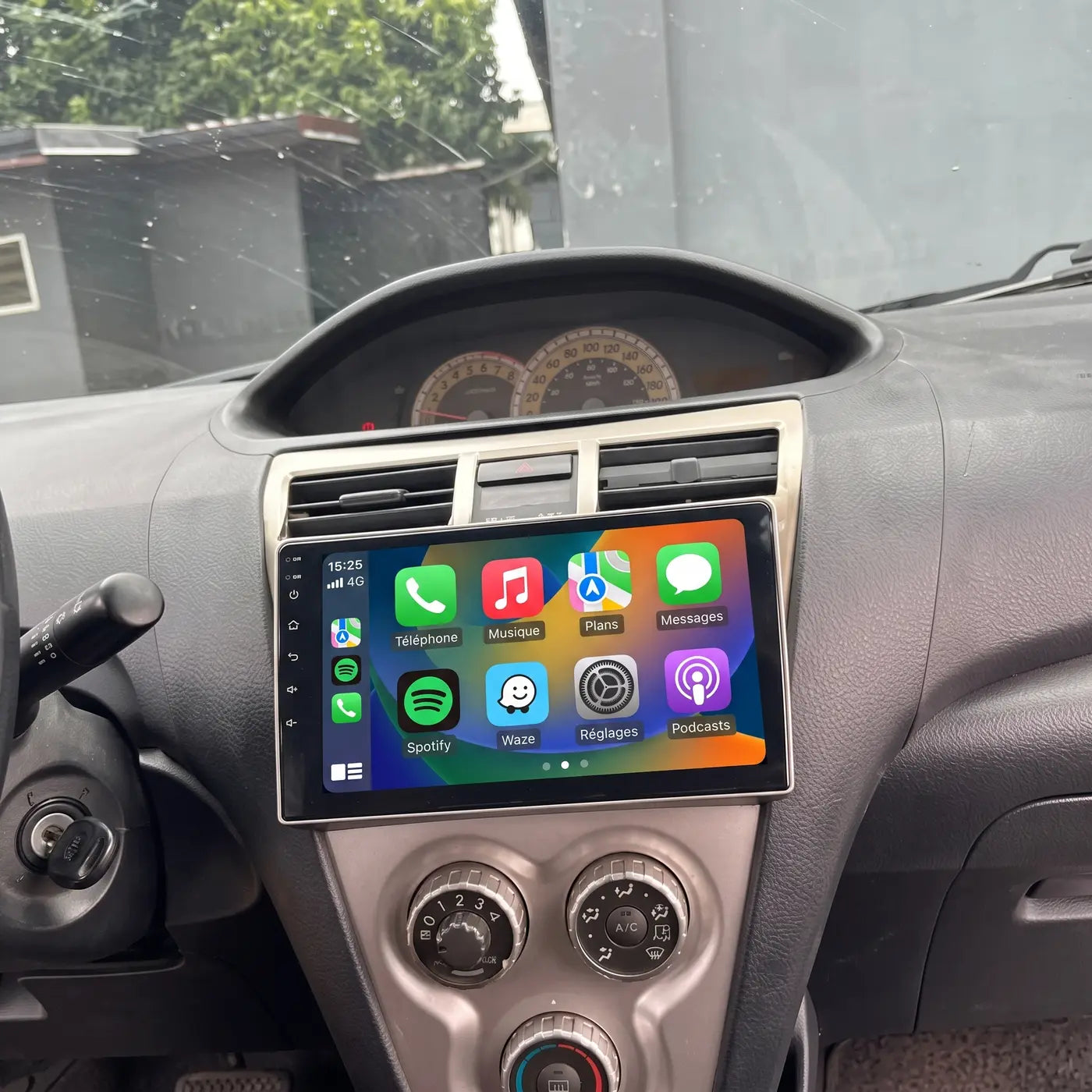 Écran CarPlay 9 pouces installé sur la console centrale d'une Toyota Yaris, écran allumé affichant les applications en français
