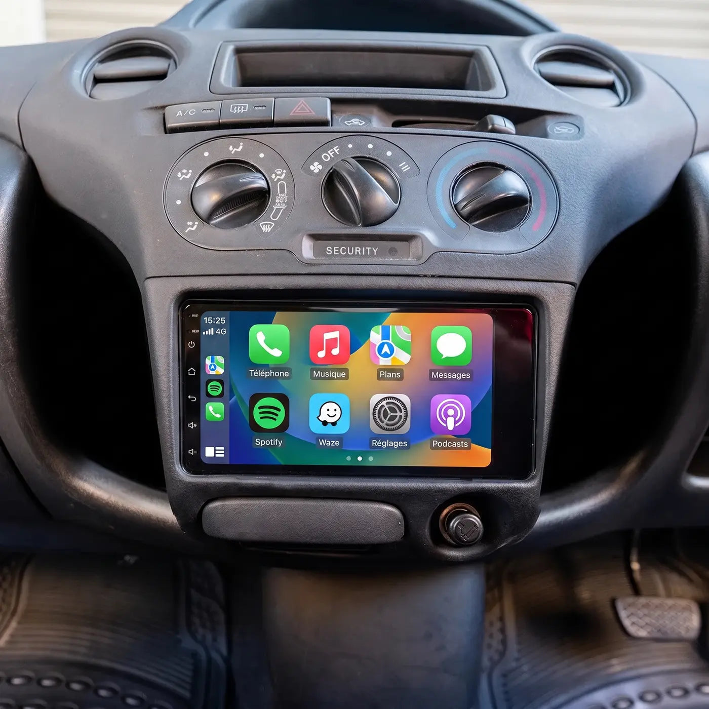 Écran CarPlay installé dans le tableau de bord d'une Toyota Yaris, sous les commandes de chauffage